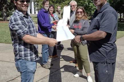 UCWGA members carry a petition with 1,000 names to the campus president's office