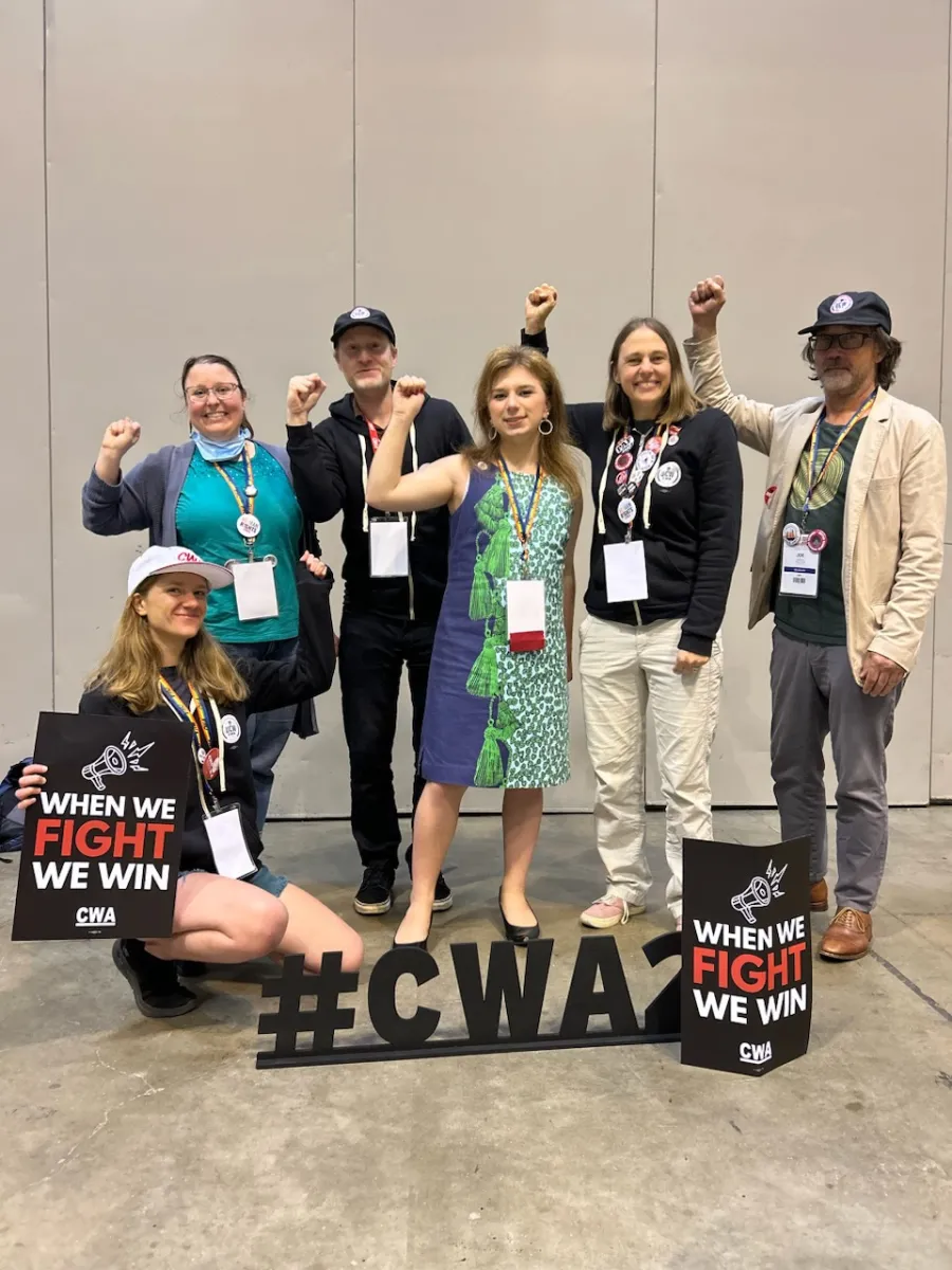 Six UCWGA Members at the CWA Convention. One is holding a sign that says: "When We Fight We Win".
